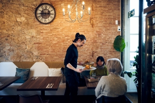 Un cambrer del restaurant Tiberius de la plaça del Mercat serveix el dinar a dues clientes en una imatge de dimecres passat. || Q. Pascual